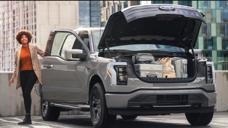 A gray 2022 Ford F-150 Lightning electric pickup truck is parked with its frunk open.