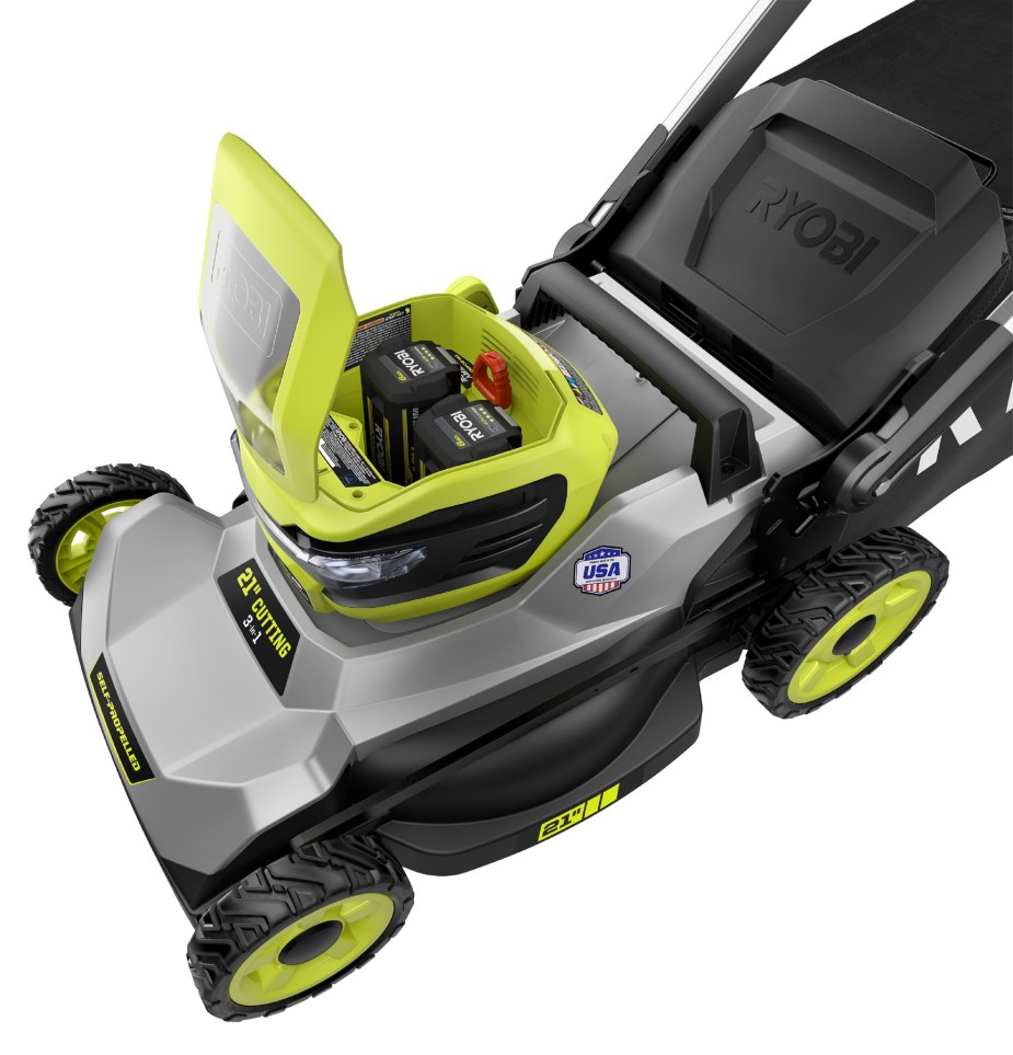 The open battery docks of a green-and-silver Ryobi RY401140US 40V HP Brushless 21” self-propelled battery-powered lawn mower