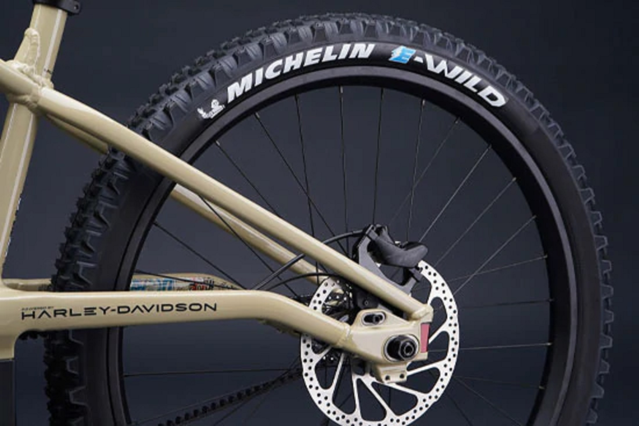 The Michelin E-Wild rear tire and rear TRP disc brake on a tan Serial 1 BASH/MTN electric mountain bike
