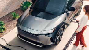 Someone is charging a gray 2023 Toyota bZ4X electric SUV.