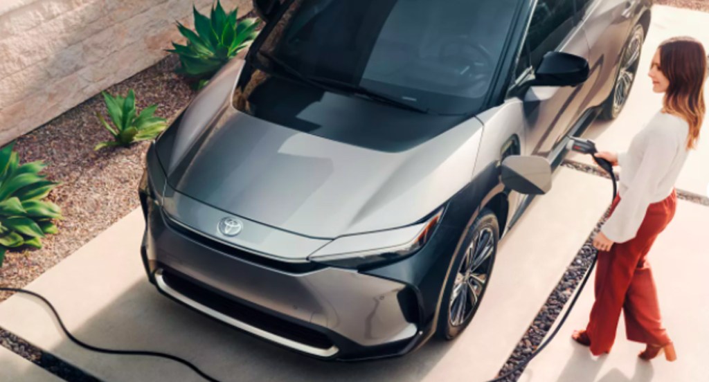 Someone is charging a gray 2023 Toyota bZ4X electric SUV.