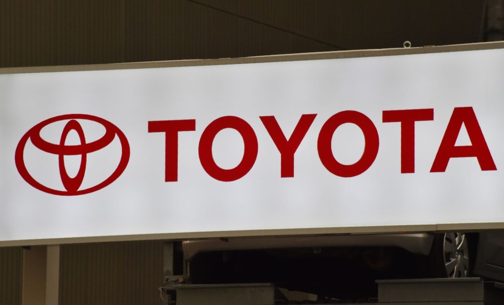 A white Toyota sign with Toyota written in red, makers of the Toyota Crown. 