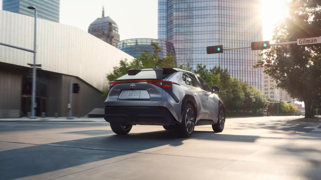 An electric SUV from Toyota, the bZ4X cruises in an urban environment. 