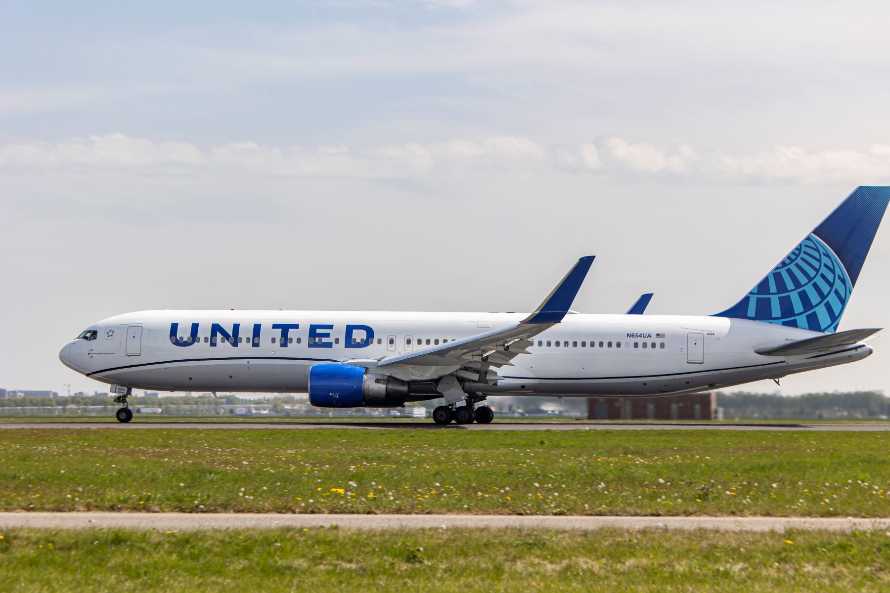 A United Airlines Boeing 767-300 aircraft model departing Amsterdam Schiphol Airport