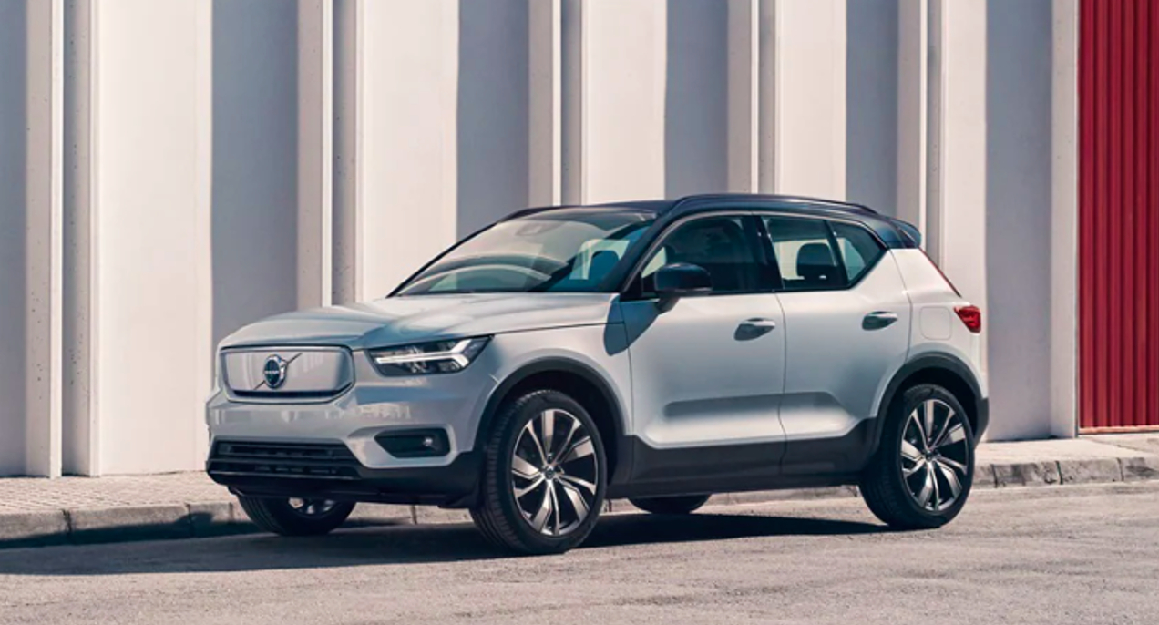 A white Volvo XC40 Recharge Pure Electric SUV is parked outside.