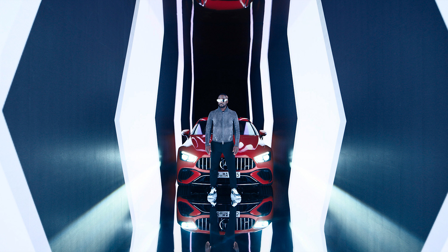Will.I.Am standing in front of a red Mercedes AMG GT 63 S E Performance during press release photoshoot