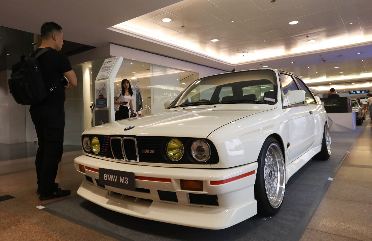 A white BMW M3 classic homologation sports car sits at a car show in Hong Kong