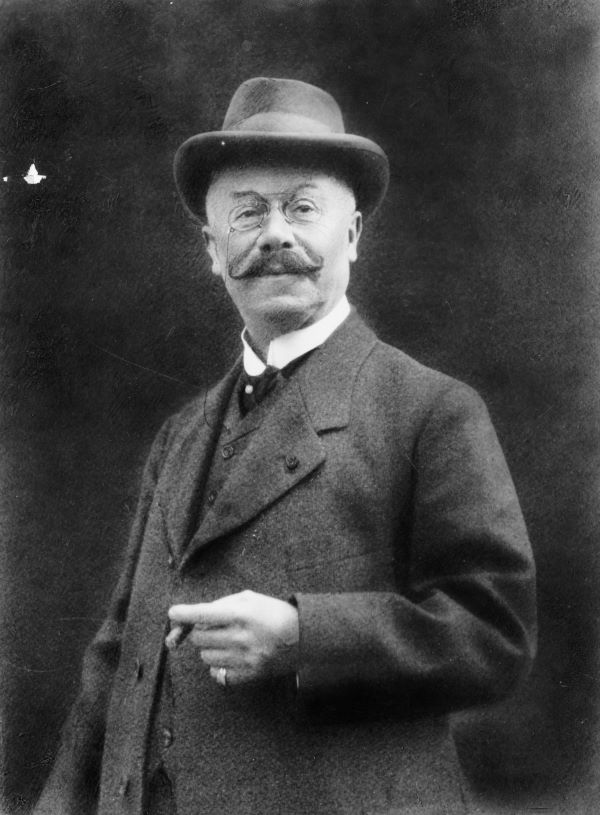 Black-and-white portrait of Emil Jellinek, businessman and father of Mercedes Jellinek. He wears a bowler hat and small glasses, and has a waxed and curled mustache