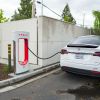 A white Tesla Model X charging at a supercharger EV charging station