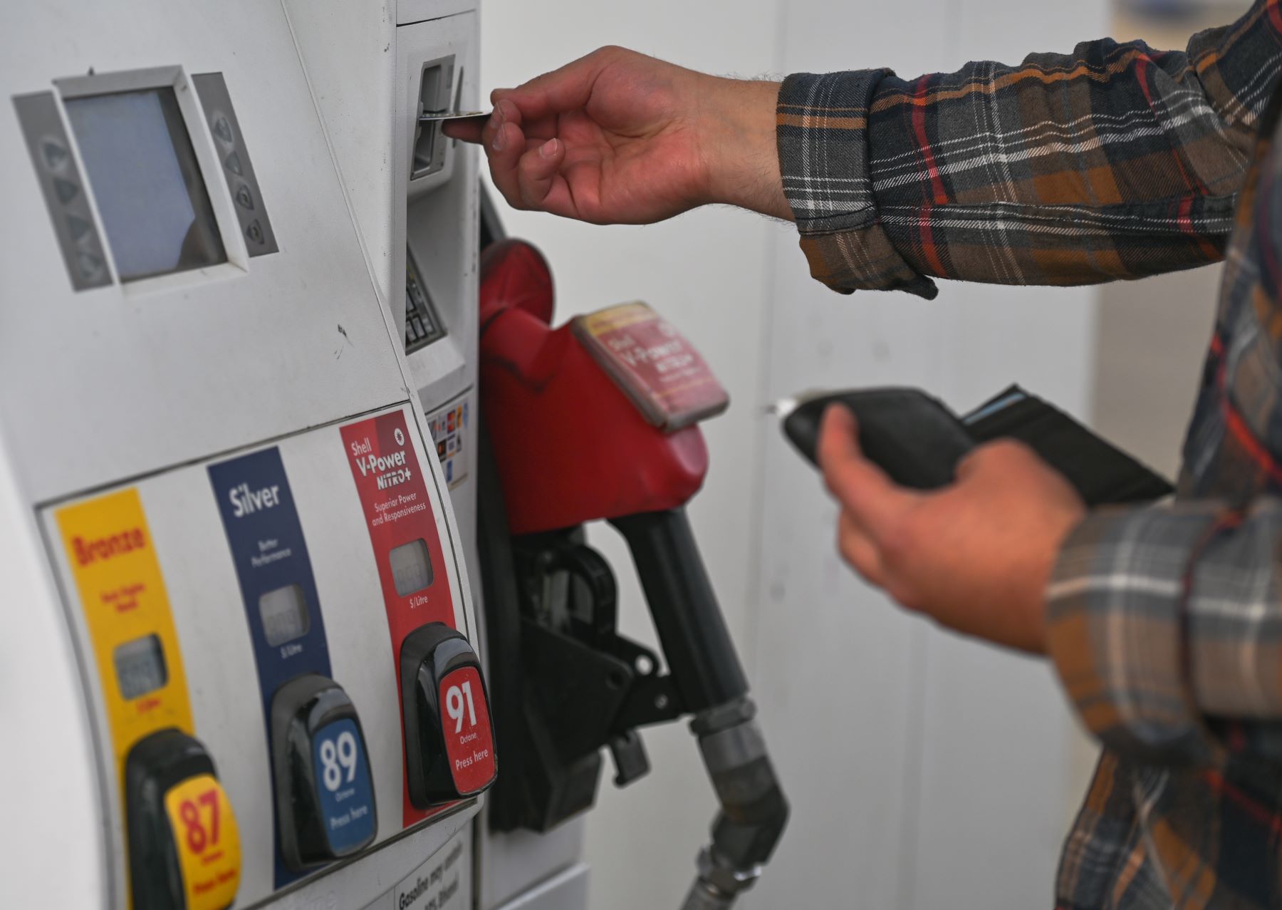 A driver using a credit card at a gasoline pump station in Edmonton, Alberta, Canada