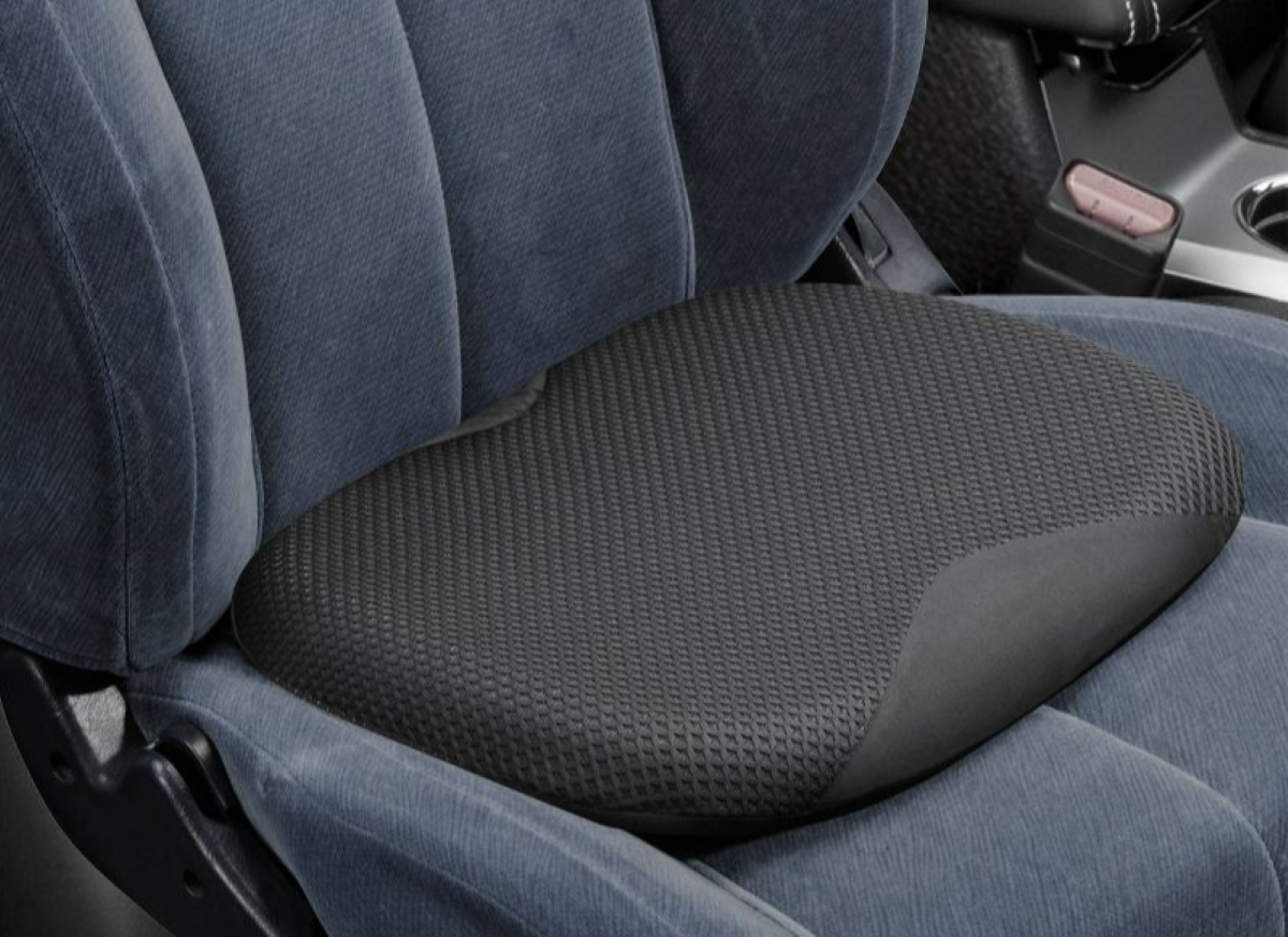 Black gel seat cushion, one of the best car interior accessories, on a car seat in blue fabric
