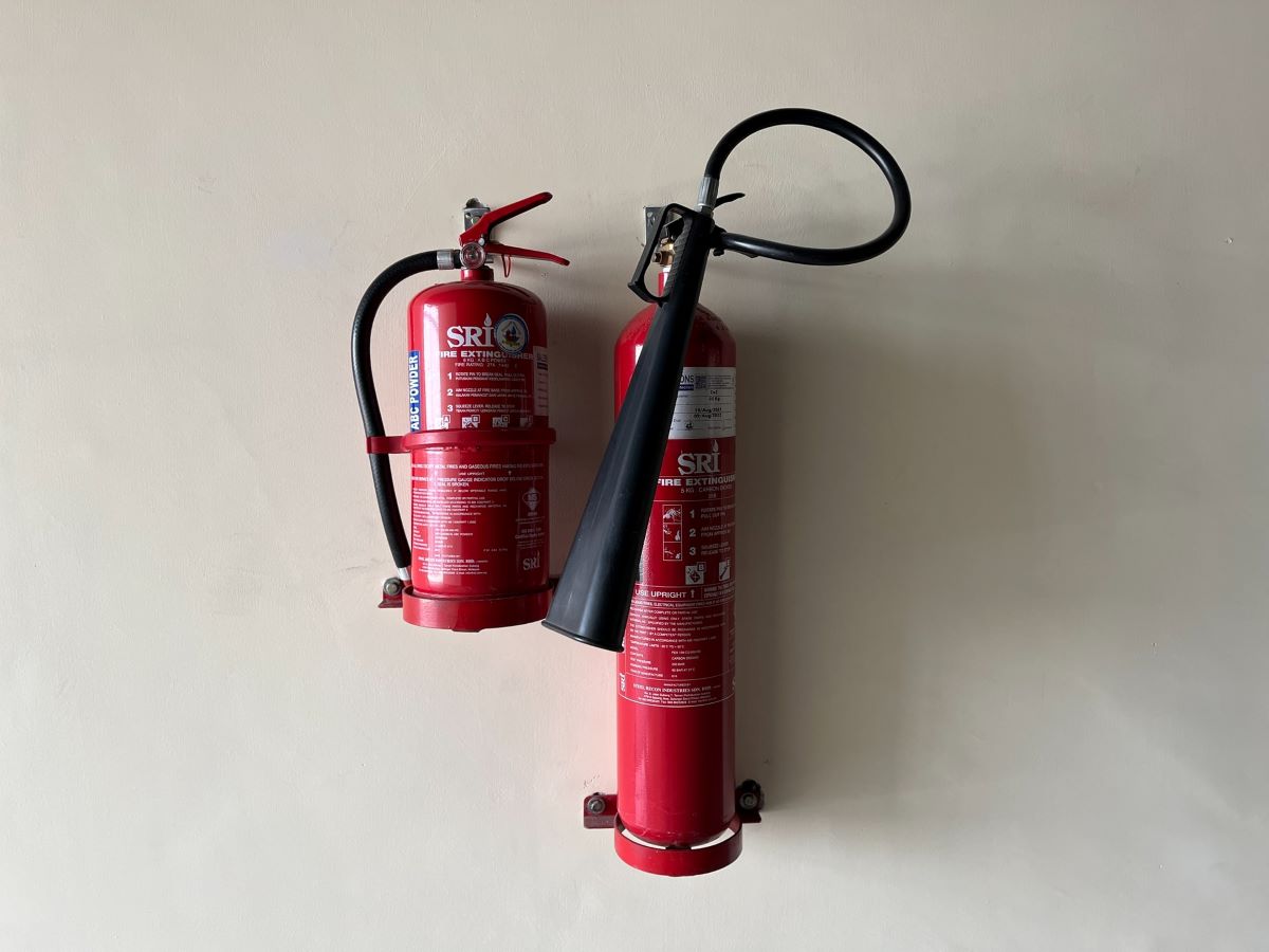 Set of fire extinguishers installed in brackets on a wall