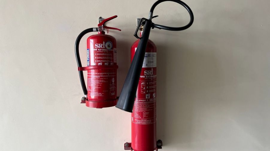 Set of fire extinguishers installed in brackets on a wall