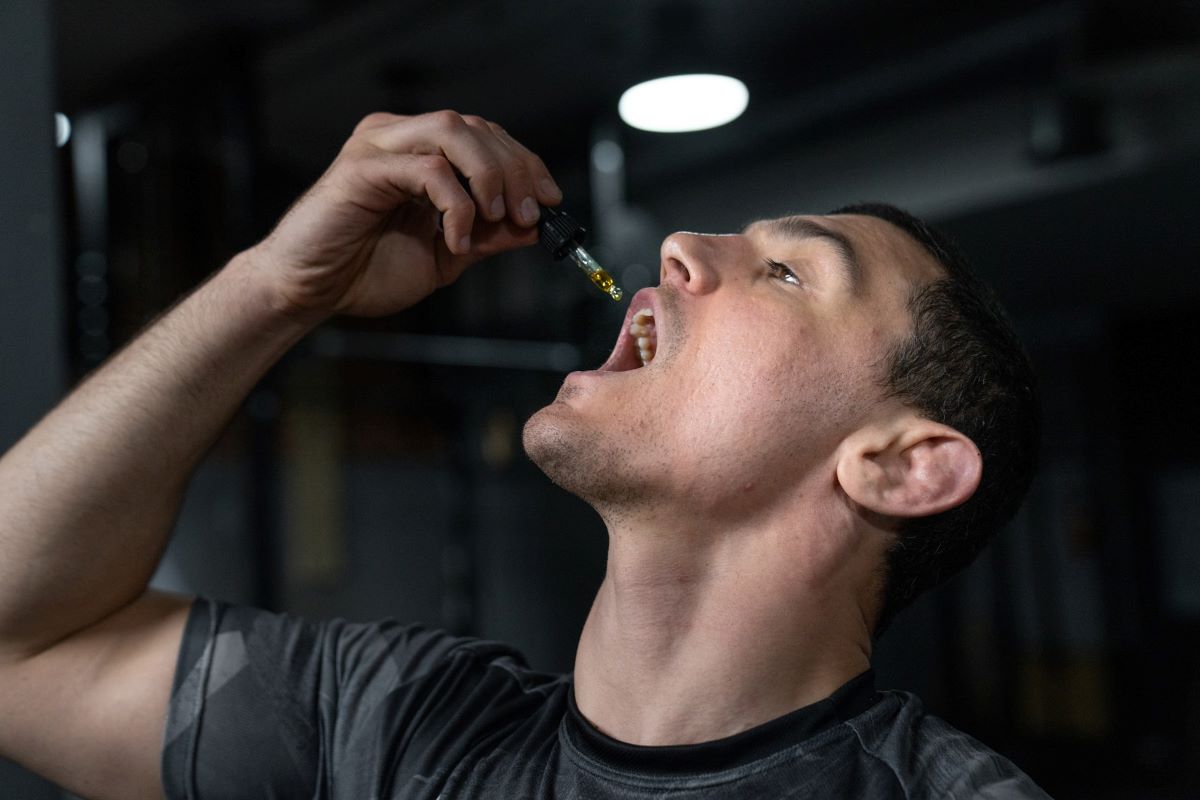 A white male takes CBD oil via a dropper directly into his mouth. Marijuana products are used by some truck drivers.