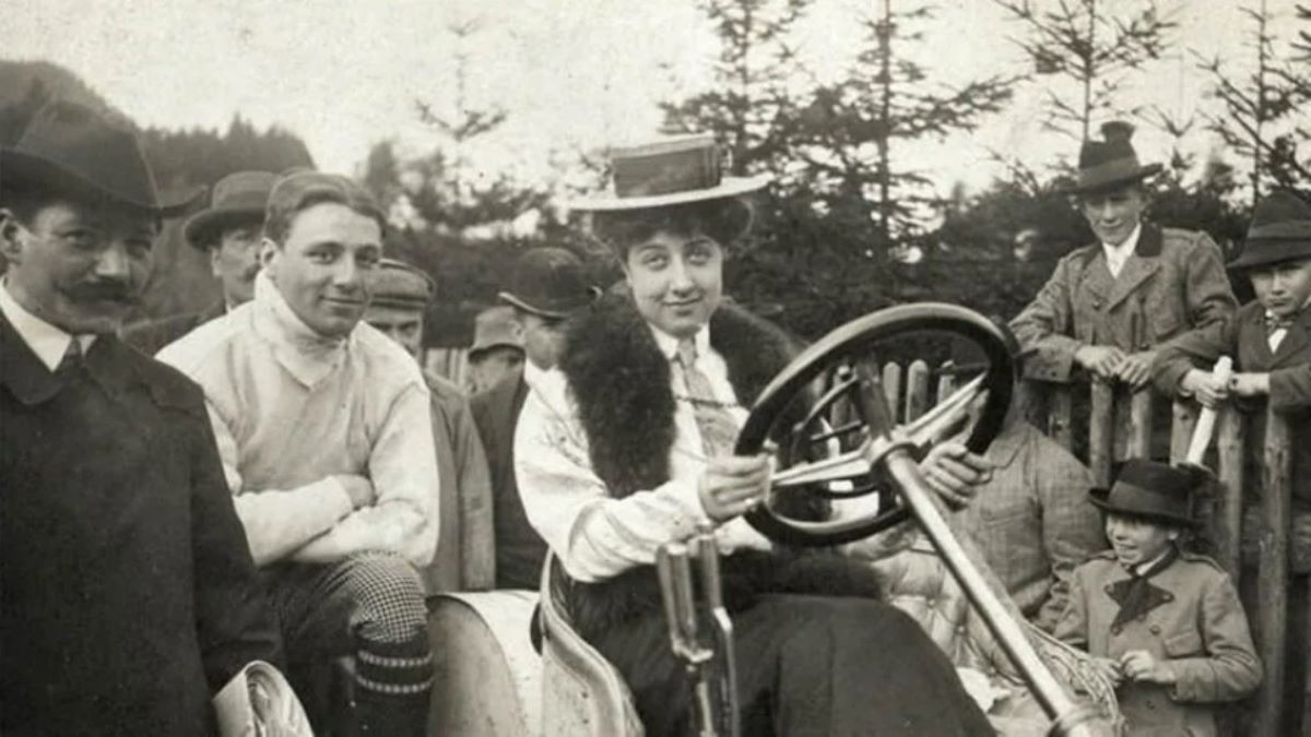 A black-and-white photo of Mercedes Jellinek sitting in one of the first Mercedes cars