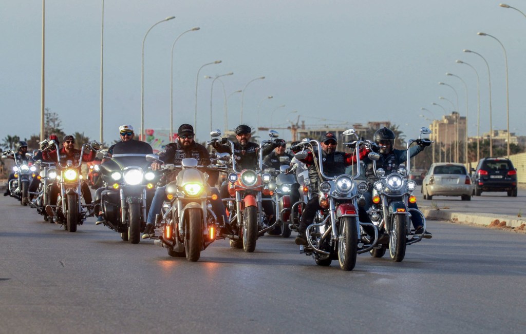 A crowd of motorcycle riders driving down the road. 