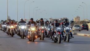 A crowd of motorcycle riders driving down the road.