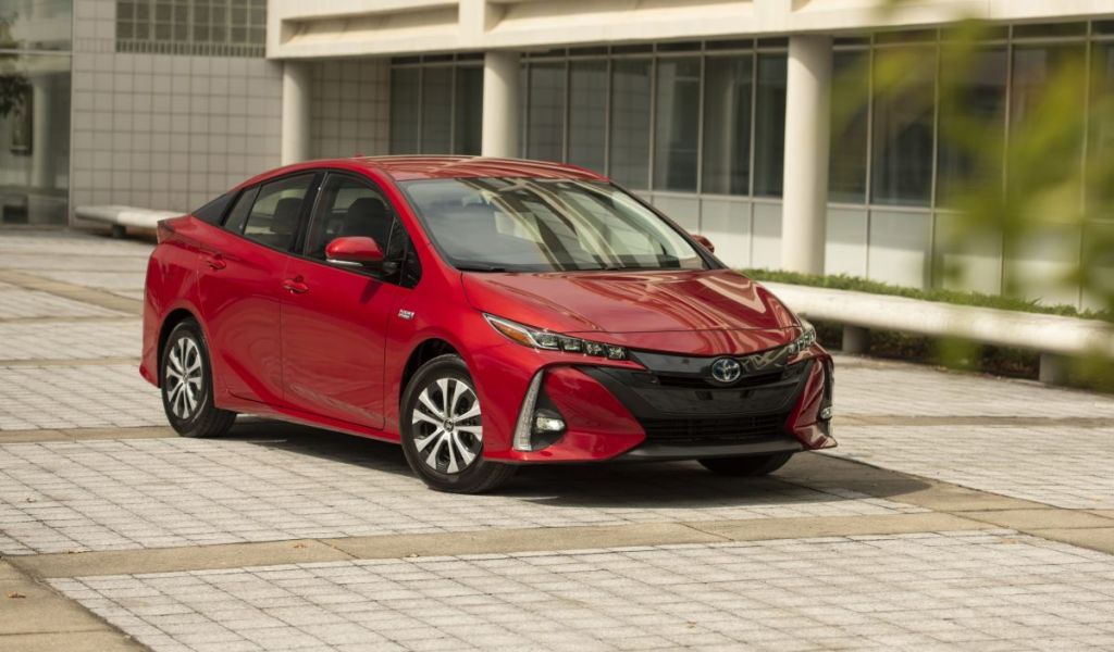 Red 2022 Toyota Prius Prime, an affordable and economical plug-in hybrid electric vehicle that competes with the 2022 Toyota Camry Hybrid