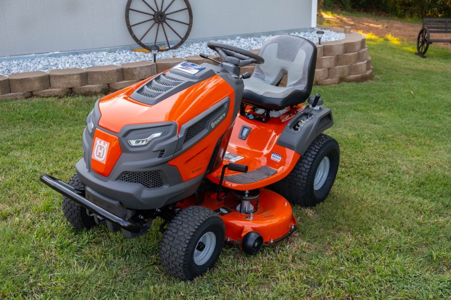 An orang Husqvarna ride-on lawn mower tractor with a deck belt.