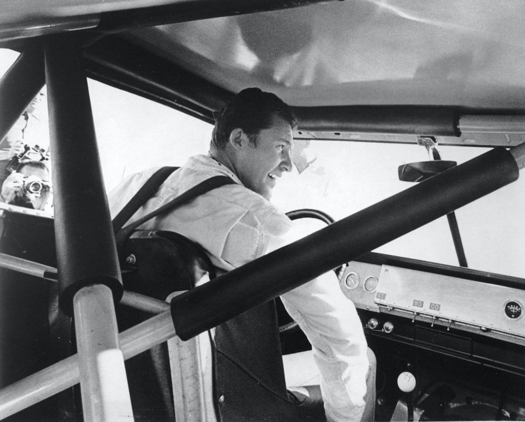 Richard Petty sits in the cockpit of his NASCAR Cup car, which shows the roll cage.