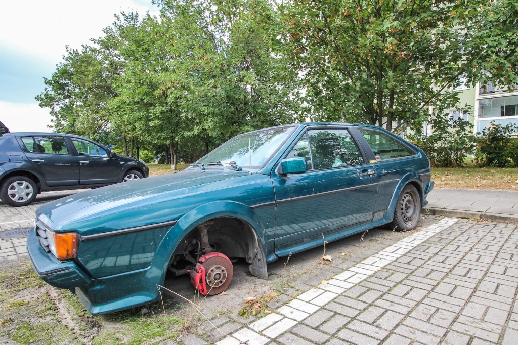 Abandoned Volkswagen Scirocco GT II car wreckage on the public parking lot.
