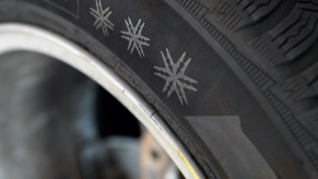 Three snowflakes are depicted on a winter tire.