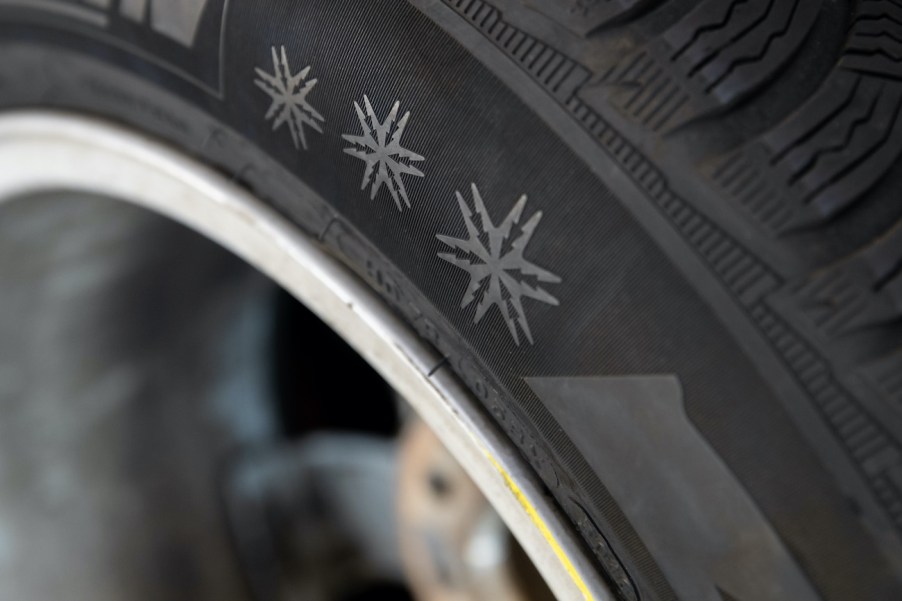 Three snowflakes are depicted on a winter tire.