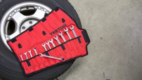 Stock photo of a toolkit on a spare tire being changed.