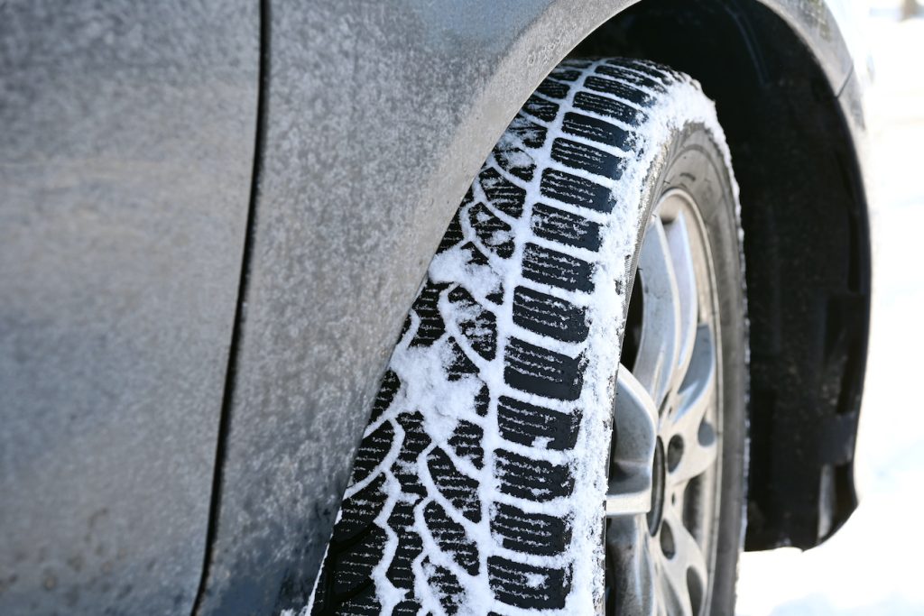 A winter tire shown on a car.