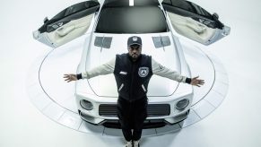 will.i.am in front of the white WILL.I.AMG Mercedes-AMG GT 4-Door concept with its rear-hinged doors open