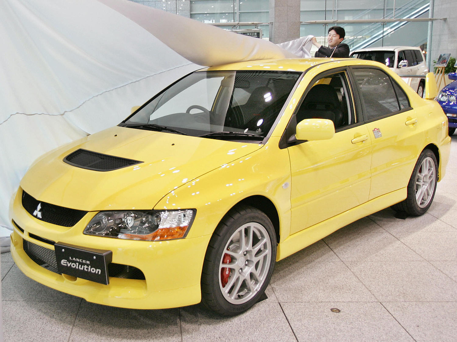A yellow 2006 Mitsubishi Lancer Evolution IX.