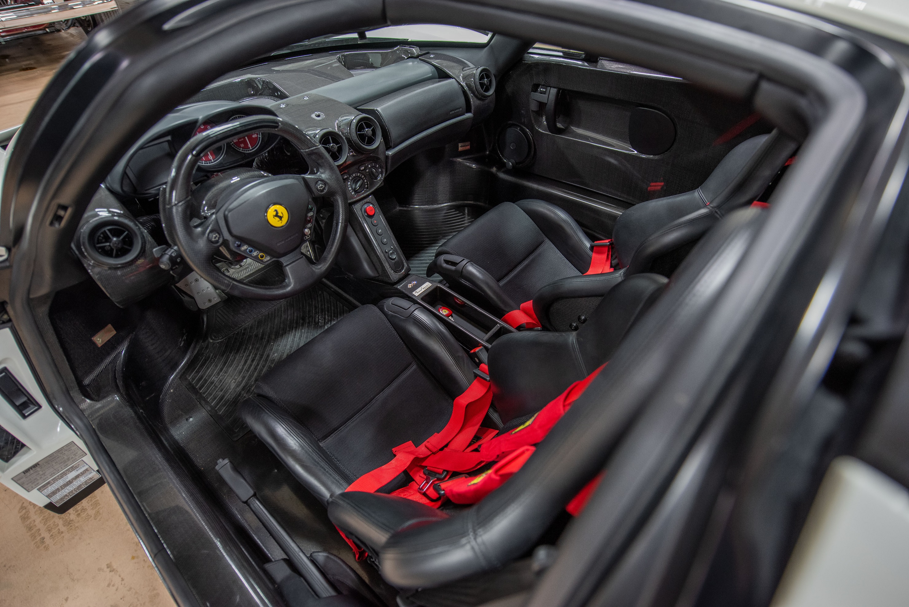 The black-leather seats with red harnesses and carbon-fiber dashboard of the 1-of-1 Bianco Avus white 2003 Ferrari Enzo