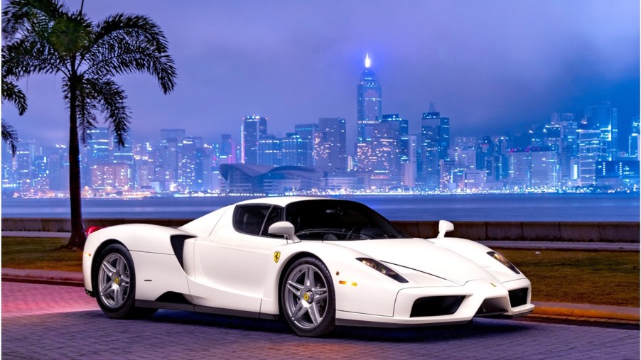 The 1-of-1 Bianco Avus white 2003 Ferrari Enzo in front of a nighttime city skyline