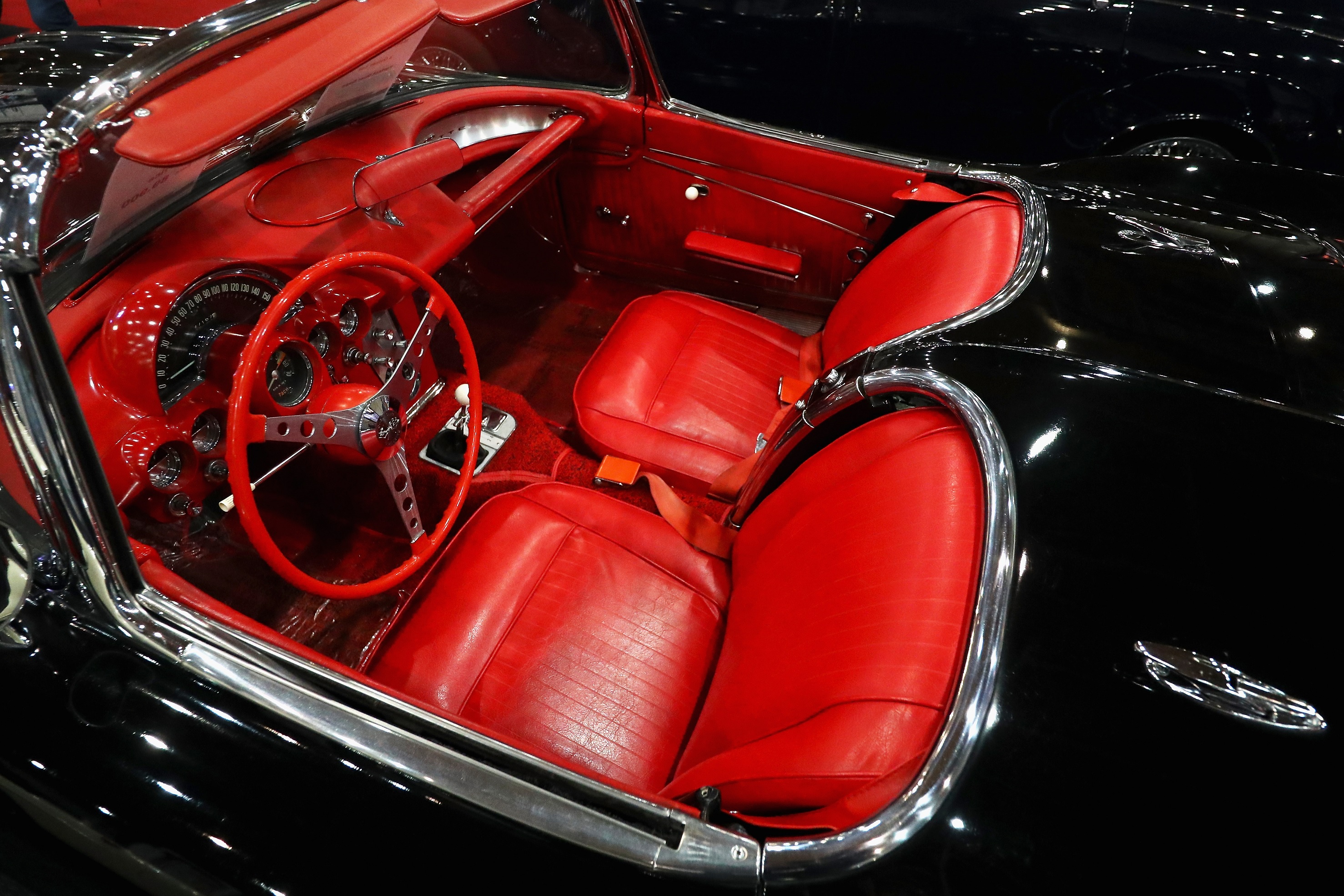 The red-leather interior of a black 1962 Chevrolet Corvette