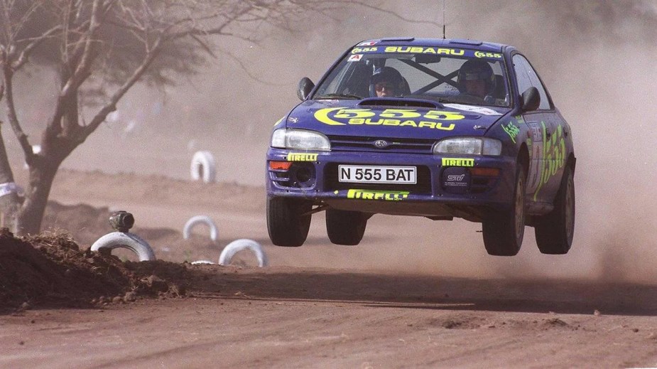 The blue 1996 Prodrive Subaru Impreza Group A WRC car driven by Pierro Liatti jumping at Rally Argentina