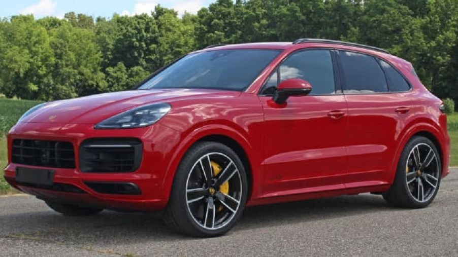 A red 2022 Porsche Cayenne in front of trees.