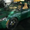 a green 2005 lotus elise sitting in a show room waiting to be purchased