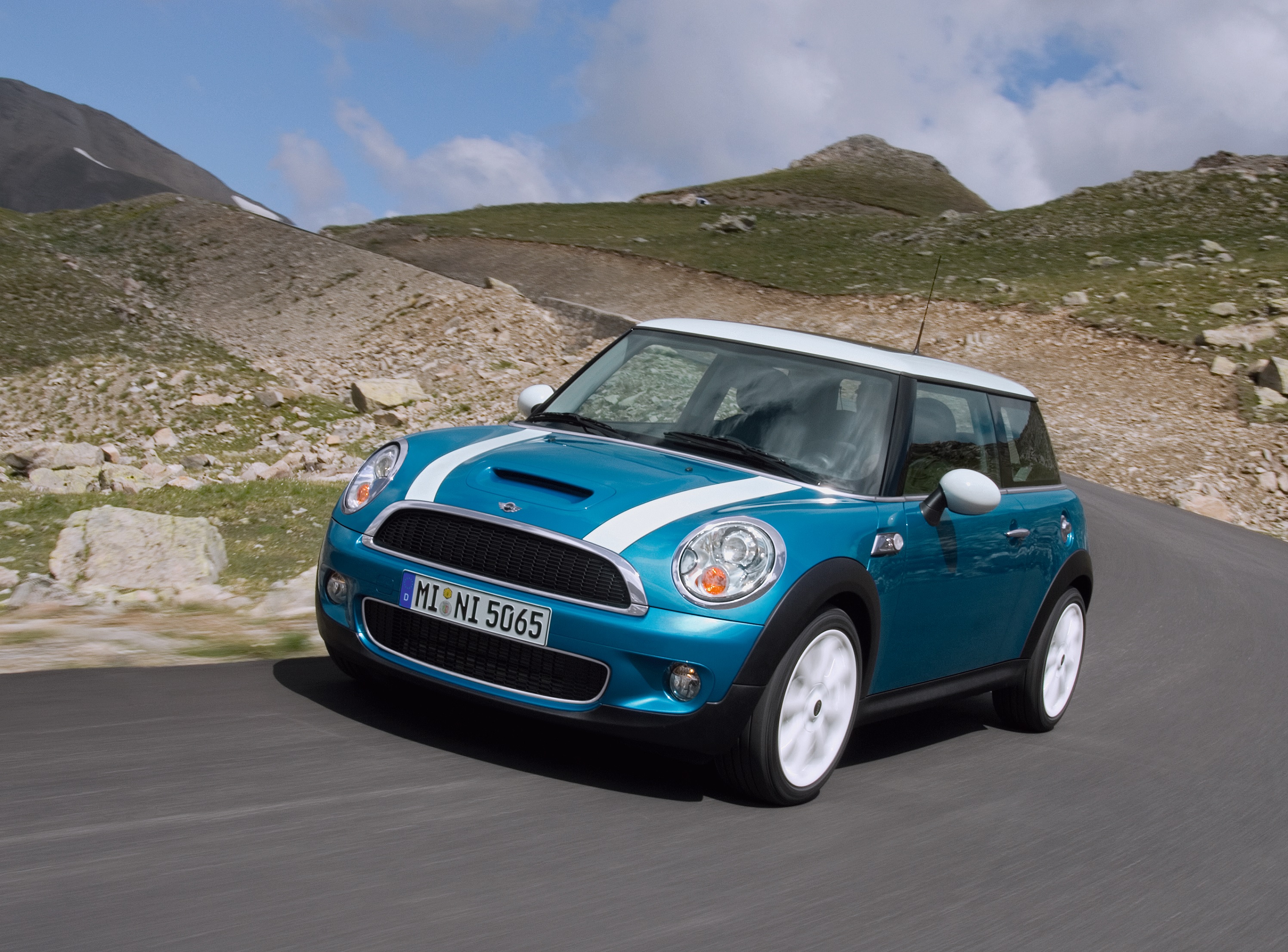 A teal 2007 R56 Mini Cooper S driving around a mountain road