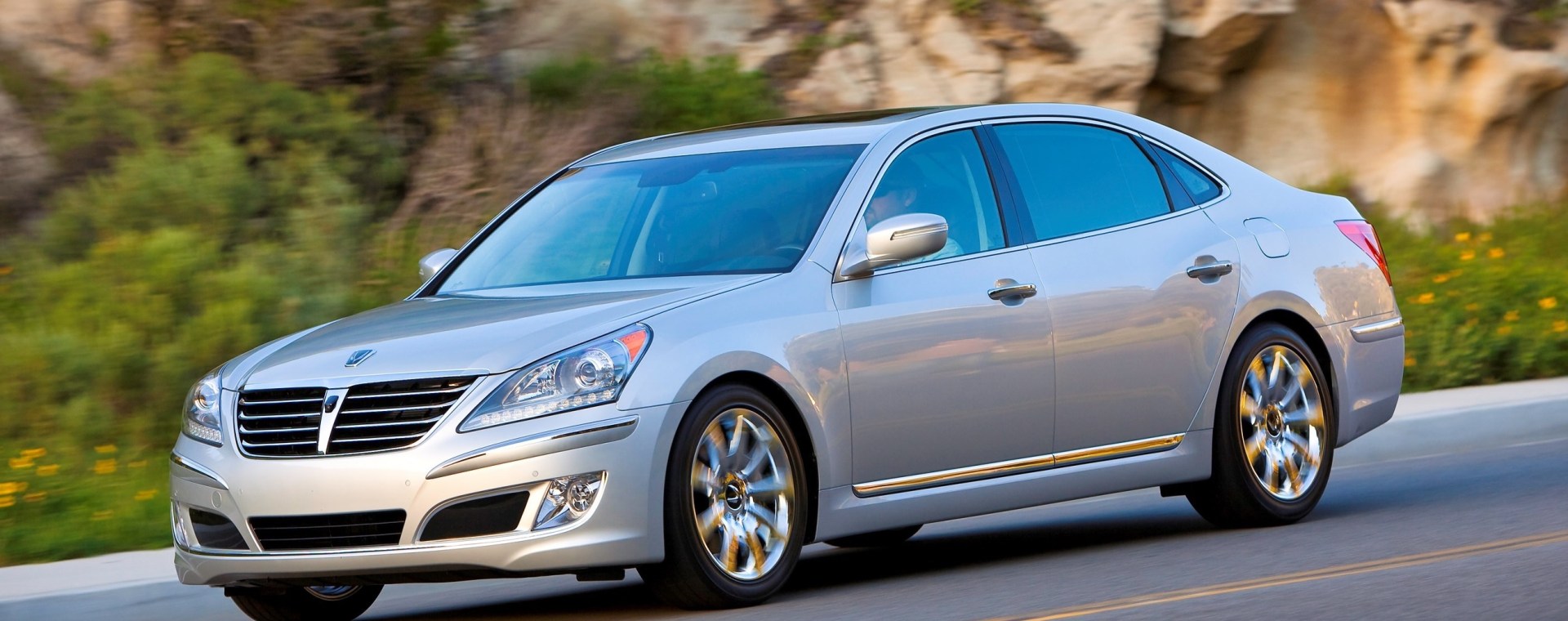 A silver 2011 Hyundai Equus full-size sedan driving down a canyon road