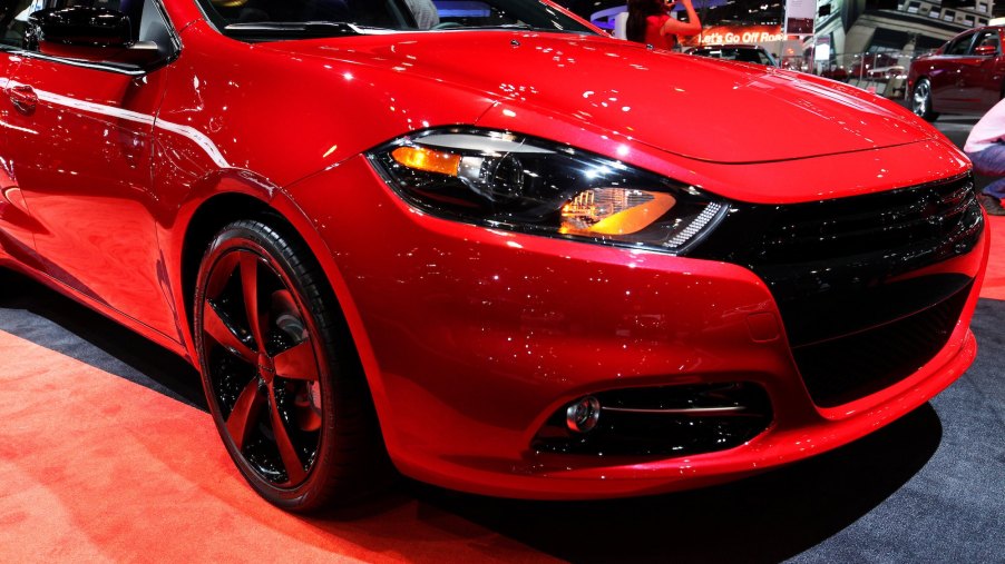 A red 2014 Dodge Dart, known to be among the cheap cars, parked indoors.