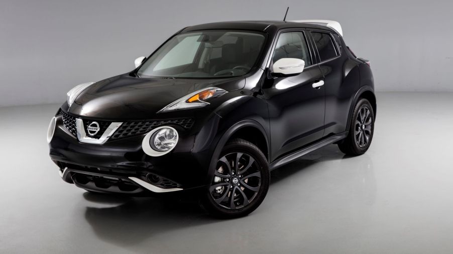 A black Nissan Juke in a white and black room.