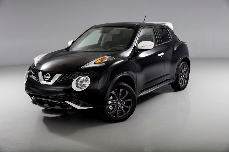 A black Nissan Juke in a white and black room.