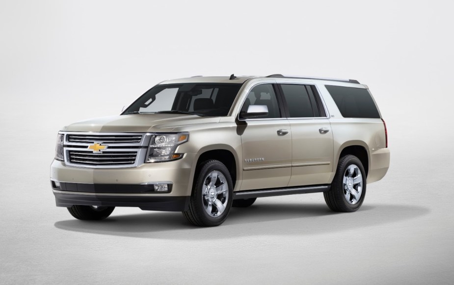 A gold 2017 Chevy Suburban against a beige background.