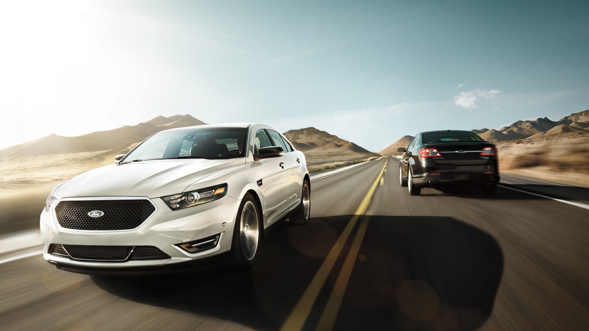 two different 2019 ford taurus sho models speed by each other, the last of a sports sedan aimed at the common driver with a great ecoboost v6 engine