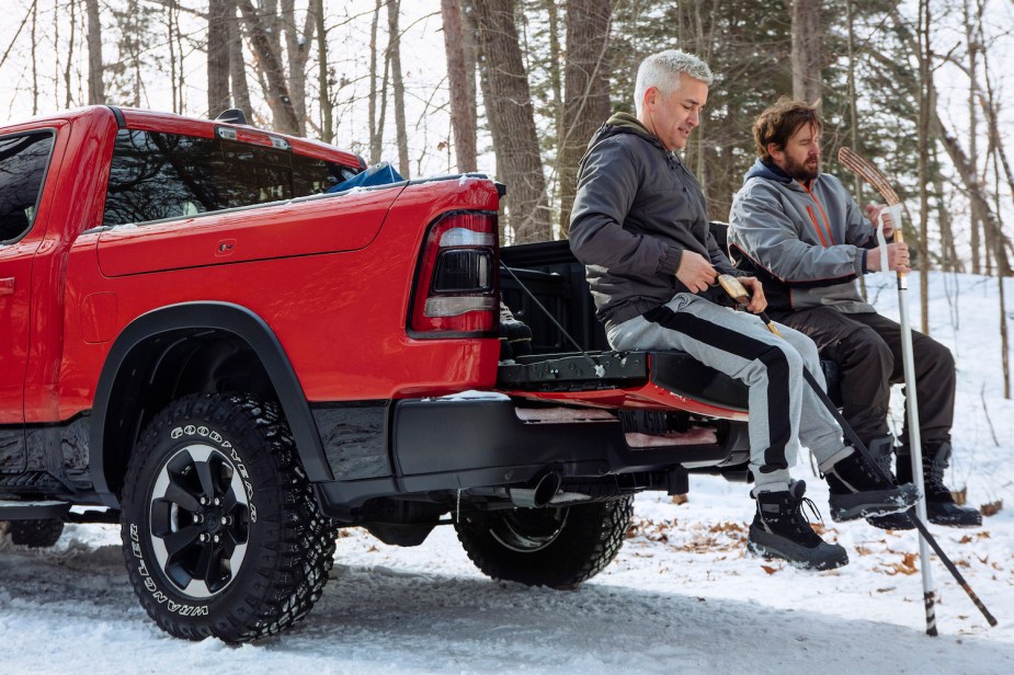 Two hockey players sit on the Ram 1500's multifunctional tailgate.