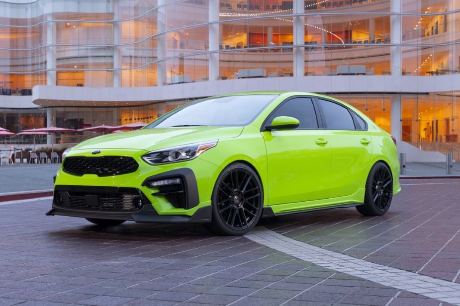 Lime green 2019 Kia Forte compact sedan parked in front of a building