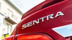Silver SENTRA badging on a red 2019 Nissan Sentra compact sedan
