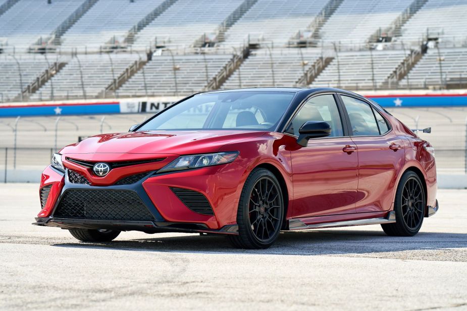 A 2022 Toyota Camry TRD midsize sedan model with the Supersonic Red color option parked on an empty race track