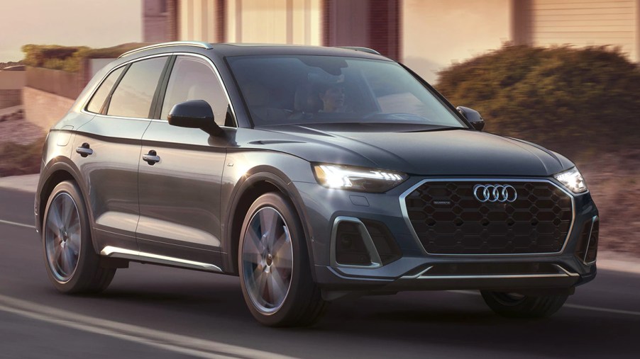 A blue 2022 Audi Q5 luxury compact SUV is driving on the road.