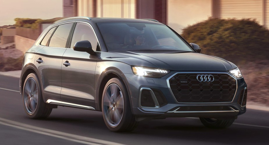 A blue 2022 Audi Q5 luxury compact SUV is driving on the road.